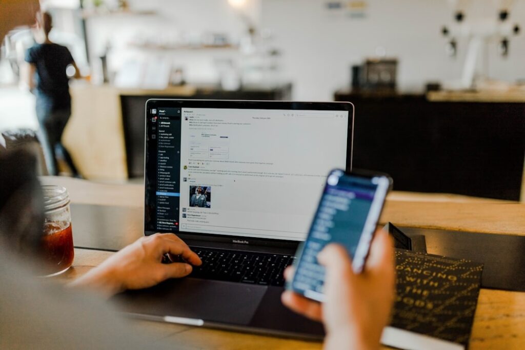 Person working on laptop and smartphone reviewing AI Vision and Accelerator Framework document – CatapultAI resource