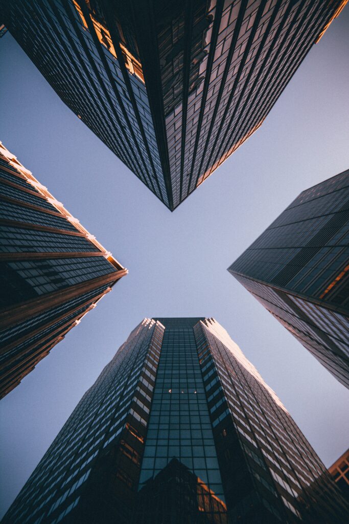 Picture of four buildings, shot from the ground up to the sky representing innovation with AI and automation. Get started with CatapultAI's Free AI tools & templates
